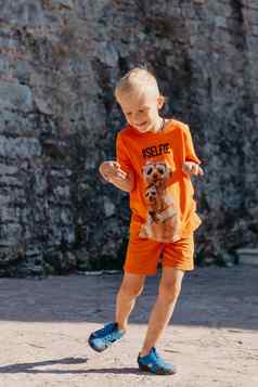 儿童户外活动微笑蹒跚学步的男孩穿橙色短裤跳运行有趣的后院阳光明媚的热夏天一天完整的长度精力充沛的男孩时尚的休闲装跳户外