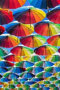色彩斑斓的雨伞蓝色的绿色红色的彩虹雨伞背景街umbrellasin天空街装饰