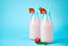 特写镜头草莓奶昔奶昔玻璃Jar浆果蓝色的背景