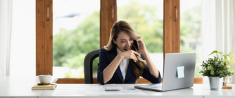 微笑亚洲业务女人工作会说话的电话采取笔记坐着工作的地方办公室复制空间横幅