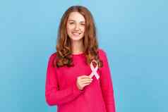 女人持有粉红色的丝带乳房癌症意识女健康诊断癌症预防