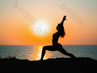 年轻的苗条的女孩练习瑜伽山海洋海日出时间轮廓女人射线太棒了日落