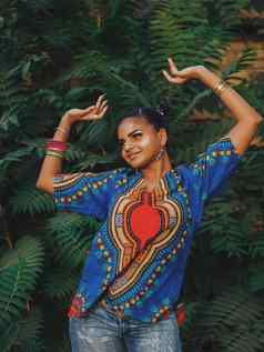 美国黑人女人跳舞户外多少数民族女孩穿色彩斑斓的服装摆姿势享受自然绿色热带背景