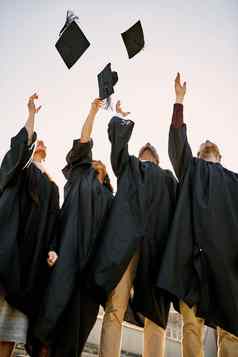 大一天庆祝活动集团学生扔帽子空气毕业一天