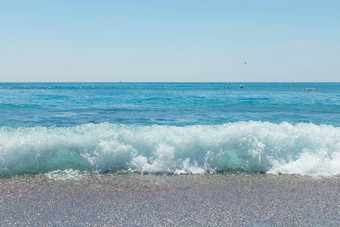 石头鹅卵石海滩蓝色的海天空卵石海滩Azure海水小波岩石水洗海岸线鹅卵石海滩明亮的阳光明媚的一天旅行假期假期海概念