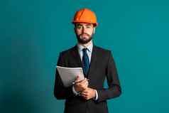 年轻的工程师商人西装夹克建设头盔文档建筑项目报告商人孤立的蓝色的背景建设满意