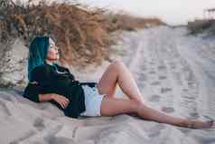 女人不寻常的蓝色的染色头发铺设桑迪海滩女孩放松自然景观