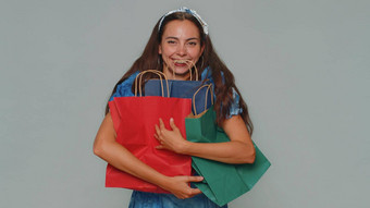 快乐微笑年轻的女人显示购物袋广告折扣惊讶低价格