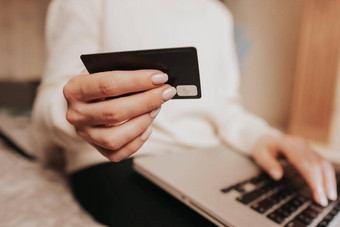 认不出来女人持有信贷卡移动PC电脑在线购物女商人工作首页互联网银行钱转移概念