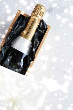 圣诞节假期香槟瓶礼物盒子闪亮的雪大理石背景