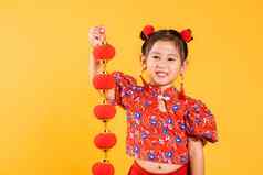 快乐亚洲中国人女孩微笑穿红色的旗袍旗袍持有丝绸灯笼