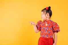 快乐亚洲中国人女孩穿红色的旗袍旗袍指出手指空间