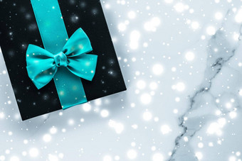 冬天假期礼物翡翠丝绸弓发光的雪冻大理石背景圣诞节礼物惊喜