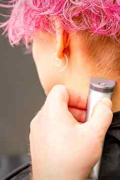 回来视图理发师的手剃须颈背脖子电微调年轻的高加索人女人短粉红色的头发美沙龙