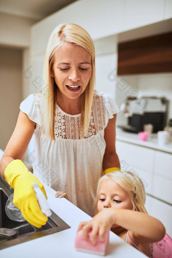 帮助妈妈做家务妈妈。女儿清洁厨房表面首页