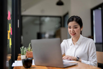 微笑年轻的业务亚洲女人自由职业者工作工作移动PC电脑现代办公室会计分析报告真正的房地产投资数据金融税系统概念