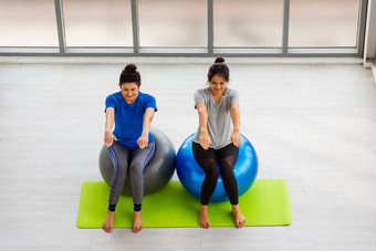 成人年轻的女人运动服装有氧运动瑜伽锻炼坐着健身球