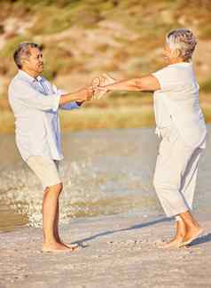 海滩退休快乐高级夫妇跳舞夏天假期假期海爱承诺浪漫跳舞有趣的上了年纪的男人。女人养老金基金旅行旅行自由