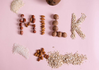 平躺刻字牛奶粉红色的背景有益健康的成分谷物坚果种子复制广告空间