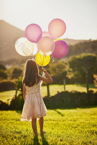 持有梦想后视镜拍摄无法辨认的女孩持有大群气球走