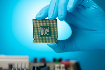 电子工程师手持有电脑芯片蓝色的背景芯片组电子电路董事会主板Cpu芯片电子组件电脑硬件电脑处理器芯片