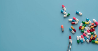 抗生素药物选择多色的胶囊药片蓝色的背景钳选择红白胶囊抗生素胶囊药片机会选择概率抽样