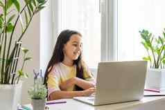 兴奋青少年女孩坐着生活房间移动PC网络研讨会首页在线学校测试概念