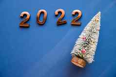 黄金数字一年假期庆祝活动概念蓝色的背景快乐一年问候卡小绿色圣诞节树复制空间