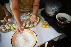 前视图烹饪洒面粉面团使自制的饺子场景手工食物准备烘焙概念