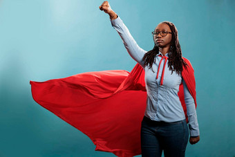 强大的勇敢的年轻的超级英雄女人穿英雄服装摆姿势飞行