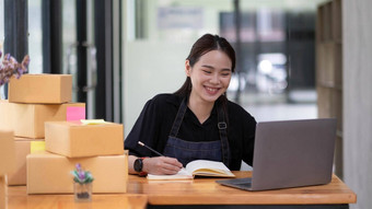 女企业家小业务锻造独立的工作首页笔记本电脑商业检查在线市场营销包装盒子锻造卖家概念在线销售