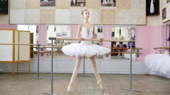 芭蕾舞大厅女孩白色包订婚了芭蕾舞排练罗尔维脚趾尖端鞋子年轻的芭蕾舞女演员站栏杆芭蕾舞大厅