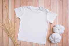 白色婴儿t恤前视图模型标志文本设计木背景平躺孩子衣服南瓜