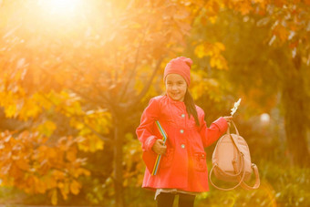 可爱的女孩运行秋天公园踢下降叶子女<strong>学</strong>生背包<strong>学校</strong>概念秋天<strong>学校</strong>研究教育童年回来<strong>学校</strong>