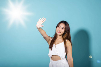 亚洲年轻的女人手封面脸保护太阳光微笑
