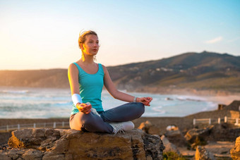 女人实践瑜伽莲花构成冥想夏天假期岩石海滩幸福放松平静女锻炼瑜伽冥想海洋海滩日落金时间