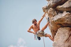 山岩石攀爬悬崖挂肾上腺素迷冒险检查安全设备钩绳子无所畏惧的男人。健身锻炼锻炼极端的体育运动