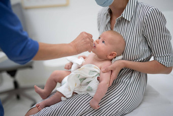 儿科医生管理口服疫苗接种轮状病毒感染婴儿存在妈妈。孩子们健康护理疾病预防