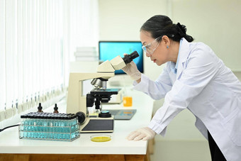 高级女人<strong>生物技术专家</strong>显微镜进行实验实验室