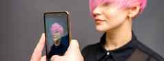 男人。理发师的手采取图片智能手机客户端短粉红色的发型