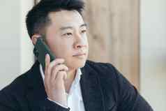 亚洲商人特写镜头肖像成功的会说话的电话业务西装