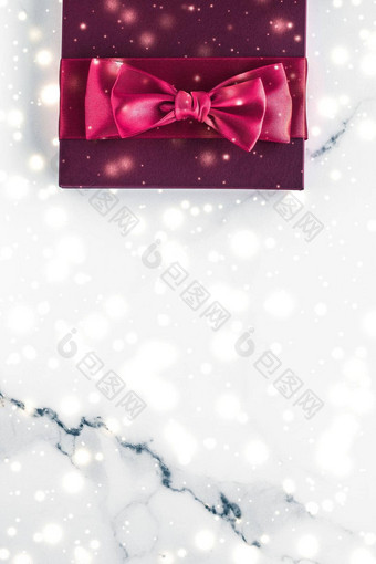 冬天假期礼物樱桃丝绸弓发光的雪冻大理石背景圣诞节礼物惊喜