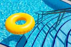 黄色的充气环浮动游泳池假期概念复制空间