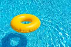 黄色的环浮动蓝色的游泳池充气环休息概念