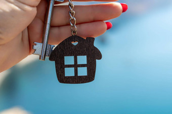 键钥匙链形状房子女手背景海概念购买房子公寓真正的房地产年轻的家庭抵押贷款贷款租赁住房