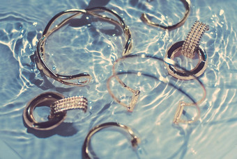 金手镯耳环环Jewelery蓝色的水背景奢侈品魅力假期美设计珠宝<strong>品牌广告</strong>