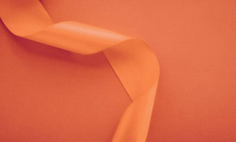 摘要卷曲的丝绸丝带橙色背景独家奢侈品品牌设计假期出售产品促销活动魅力艺术邀请卡背景