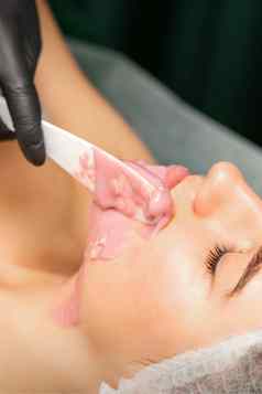 美容师应用藻酸盐剥离粉面部面具抹刀水疗中心