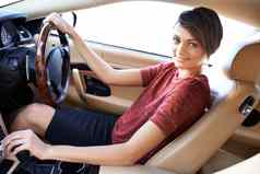 公路旅行风格美丽的年轻的女人开车奢侈品车