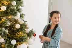 孩子女孩装修圣诞节树在室内早....圣诞节